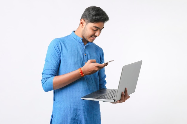 Jonge Indiase man die smartphone gebruikt en uitdrukking geeft op een witte achtergrond.