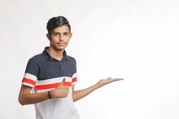 Jonge Indiase man die uitdrukking geeft met hand over witte achtergrond.
