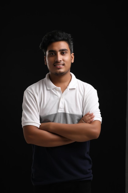 Jonge Indiase man die uitdrukking op een donkere achtergrond toont