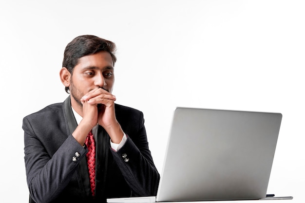 Jonge Indiase man in pak en bezig met laptop op kantoor