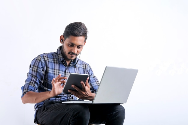 Jonge Indiase man met laptop op witte achtergrond.