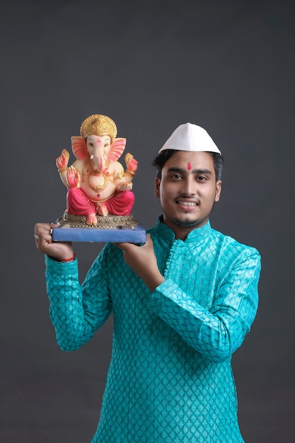 Jonge Indiase man met lord ganesha sclupture. ganesha-festival vieren.