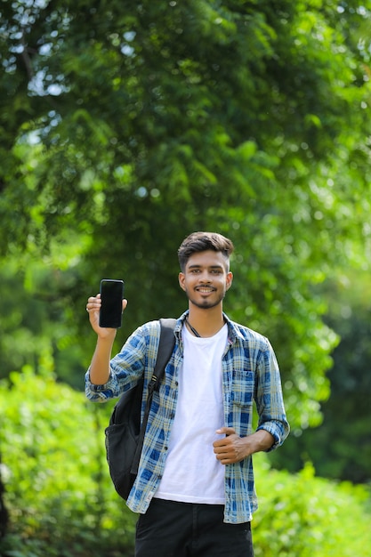 Jonge indiase man met mobiel scherm