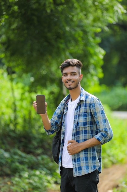 Jonge Indiase man met mobiel scherm