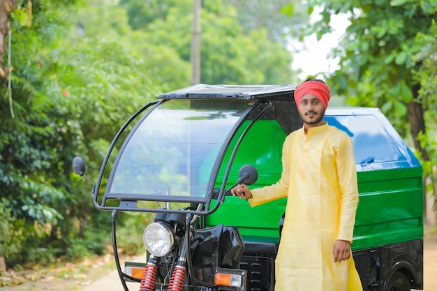 Jonge Indiase man permanent met vuilniswagen