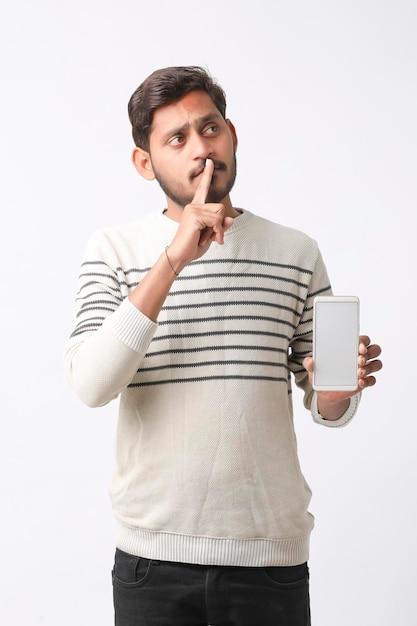 Jonge indiase man smartphone scherm tonen op witte achtergrond.