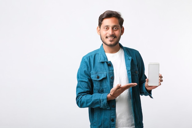 Jonge Indiase man smartphone scherm tonen op witte achtergrond.
