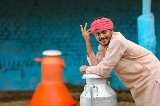 Jonge Indiase melkman op zijn boerderij