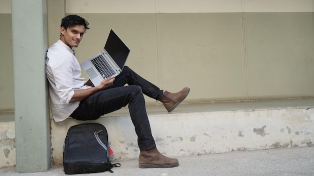 Jonge Indiase student met laptop op universiteitscampus