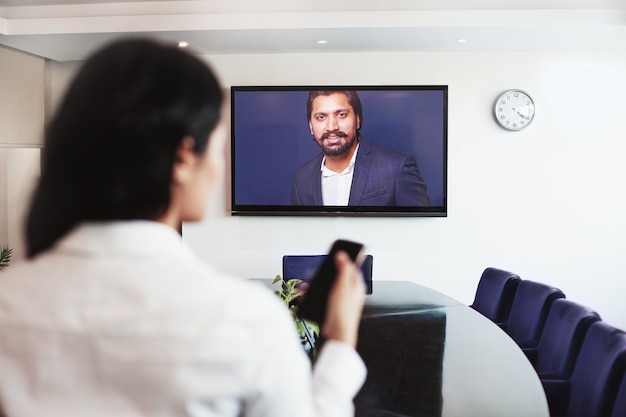 Jonge Indiase vrouw doet videoconferentie met directeur van het bedrijf