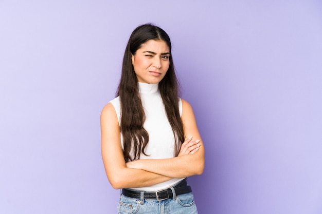 Jonge Indiase vrouw geïsoleerd op paars ongelukkig in de camera kijken met sarcastische uitdrukking.