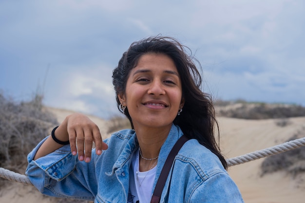 Jonge indiase vrouw gelukkig op het strand