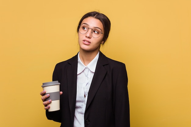 Jonge Indische bedrijfsvrouw die een afhaalmaaltijden geïsoleerde koffie drinken