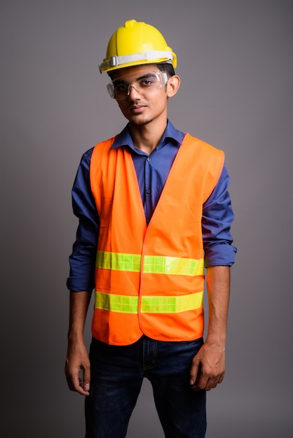 Jonge Indische mensenbouwvakker die beschermende glazen draagt