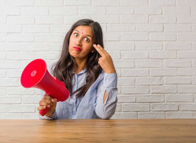 Jonge Indische vrouw die een zelfmoordgebaar maken, droevig voelen en doen schrikken zich vormt een kanon met vin