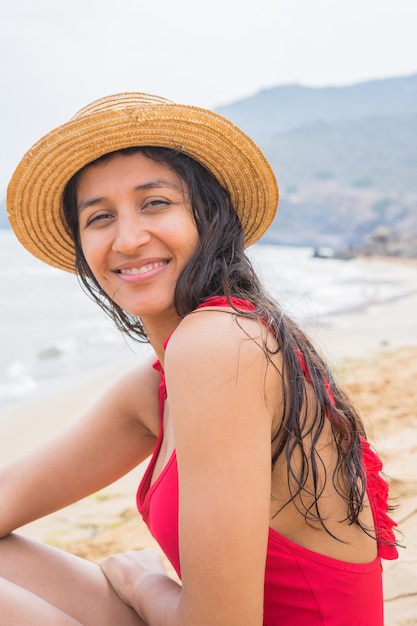 Jonge indische vrouw die gelukkig op het strand is