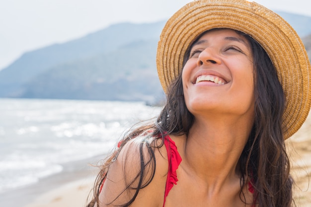 Jonge Indische vrouw die op het strand glimlacht