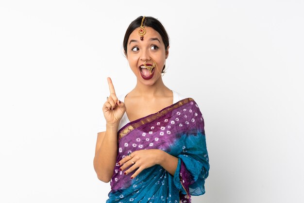 Jonge Indische vrouw die op witte muur de oplossing wil realiseren terwijl het opheffen van een vinger