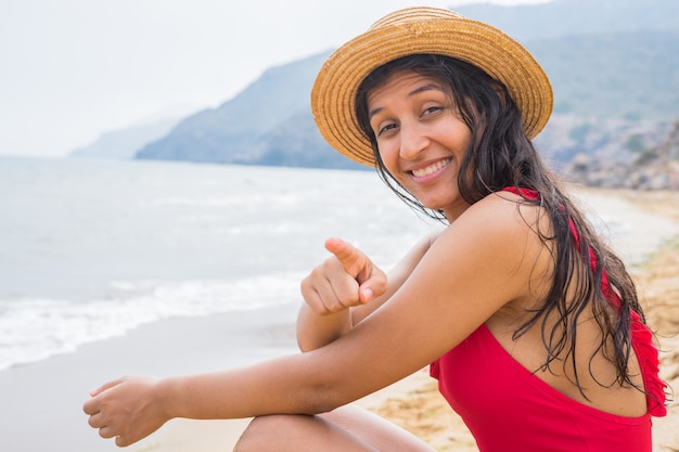 Jonge Indische vrouw die u op het strand richt