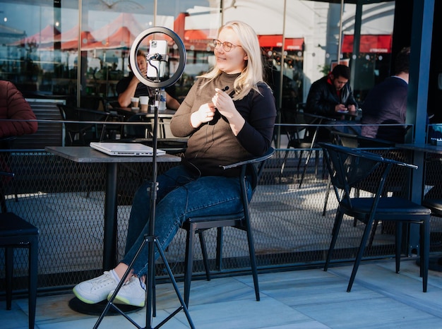 Jonge influencer voor de laptop die binnen in het café werkt smm-manager