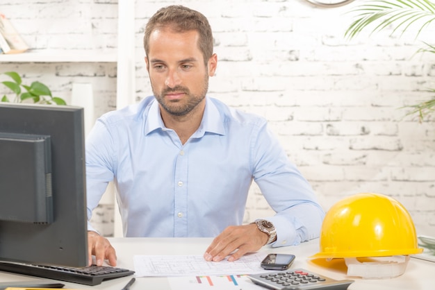 Jonge ingenieur die aan zijn computer werkt