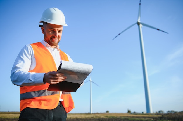 Jonge ingenieur die windturbines kijkt en controleert op het veld