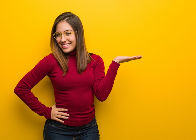 Jonge intellectuele vrouw die iets met hand houdt