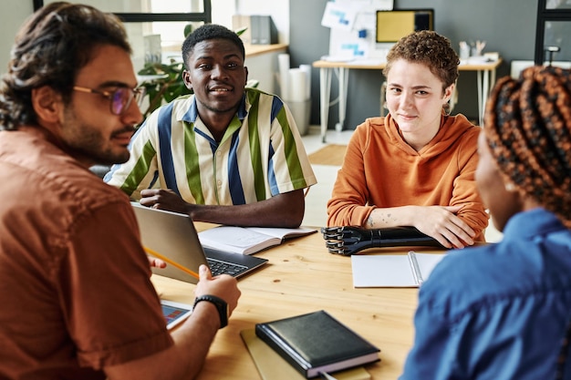 Foto jonge interculturele creatieve ontwerpers die naar hun collega luisteren