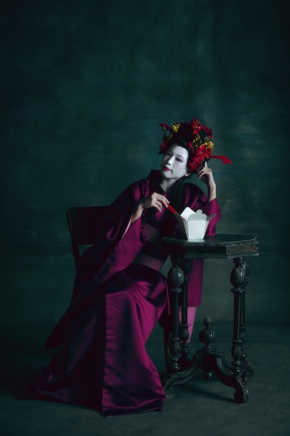 Jonge Japanse vrouw als geisha op donkere groene achtergrond retro stijl vergelijking van tijdperken concept