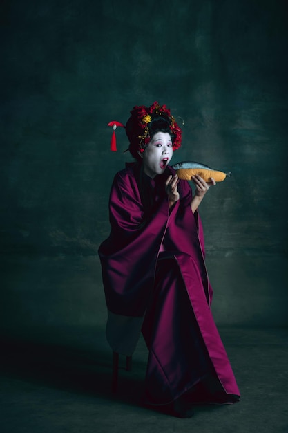 Jonge Japanse vrouw als geisha op donkere groene achtergrond retro stijl vergelijking van tijdperken concept