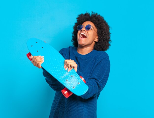 Jonge jonge afrovrouw met een skatebord