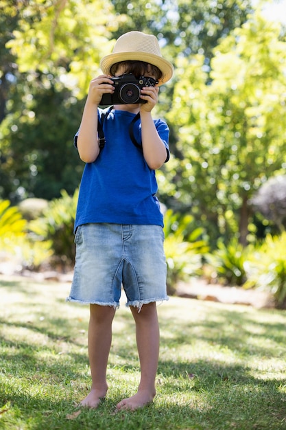 Jonge jongen die een foto van camera klikt