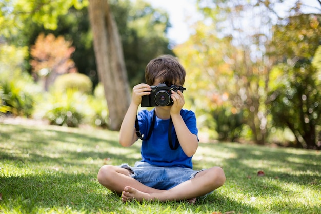 Jonge jongen die een foto van camera klikt