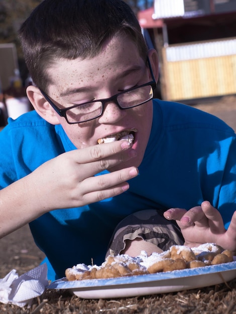 Jonge jongen die trechtercake eet.