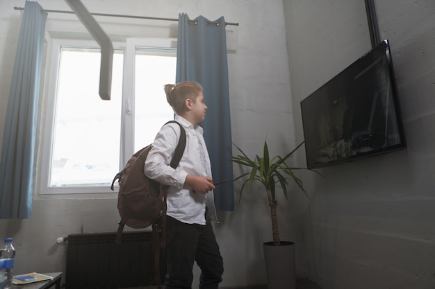 Jonge jongen die tv kijkt voordat hij naar school gaat