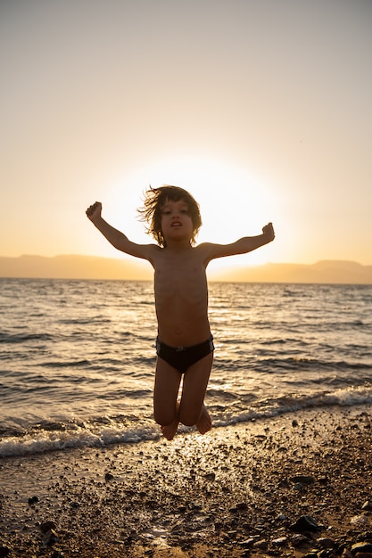 Jonge jongen die van het strand geniet