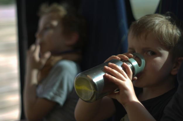 Foto jonge jongen drinkt water.
