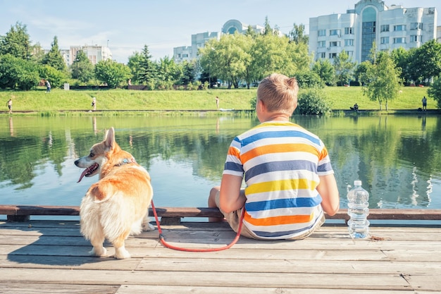 Jonge jongen en zijn hond op een houten peer