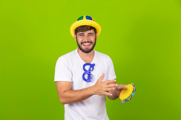 Jonge jongen gekleed voor carnaval met een tamboerijn in zijn handen Jonge man gekleed in carnaval kostuum tamboerijn spelen op carnaval feest