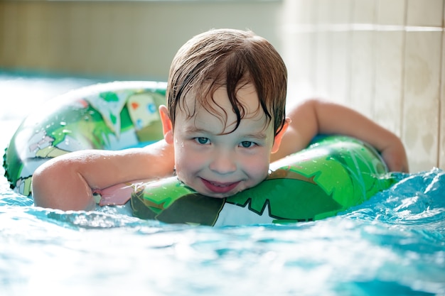 Jonge jongen in opblaasbare buis zwemmen