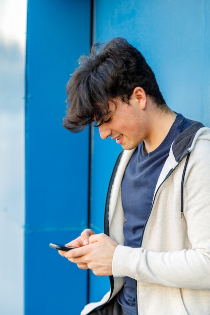 Jonge jongen met behulp van zijn mobiele telefoon