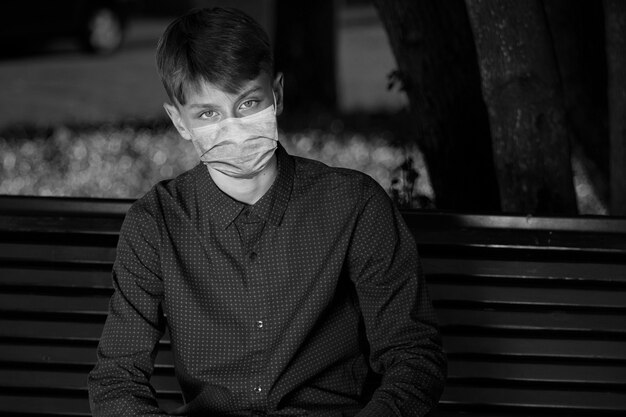 Jonge jongen met een medisch masker. zwart-wit fotografie