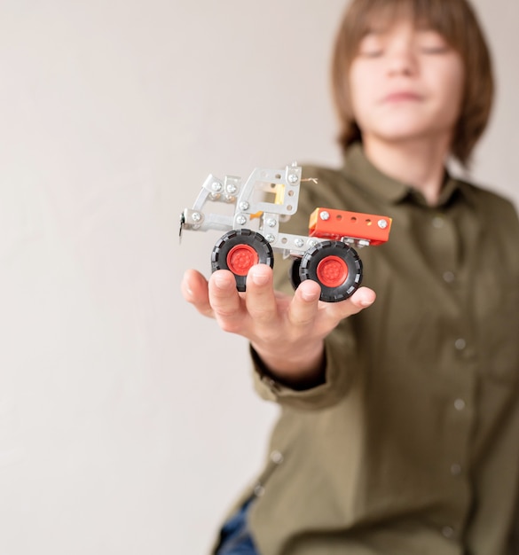 Foto jonge jongen met een speelgoedauto in zijn hand