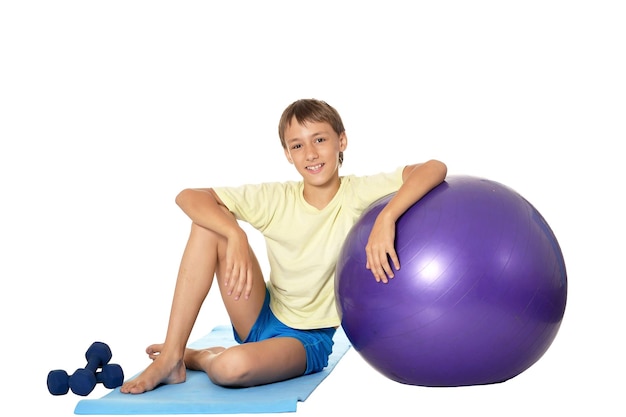 Jonge jongen met fitbal en dumbbells