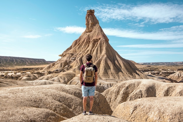 jonge jongen met rugzak en korte spijkerbroek reist in het woestijnlandschap van Bardenas Reales Navarra