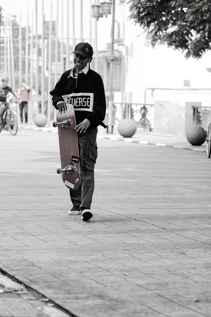 Foto jonge jongen op een skateboard.