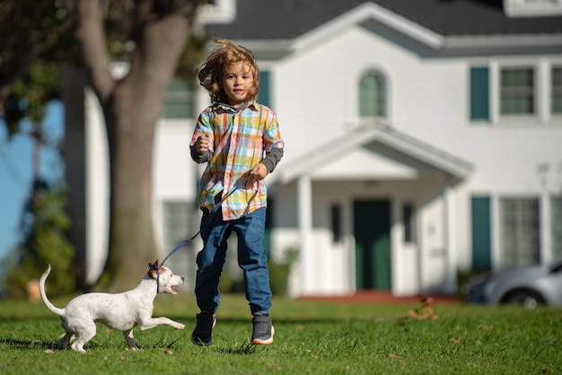 Jonge jongen rent in een groen veld met zijn huisdier