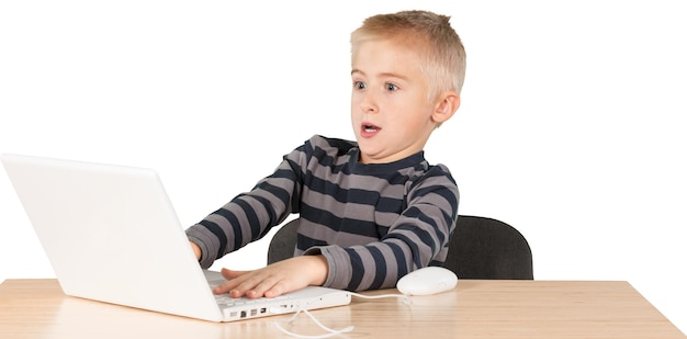 Jonge jongen speelt spel op een laptop en leunt ver naar achteren