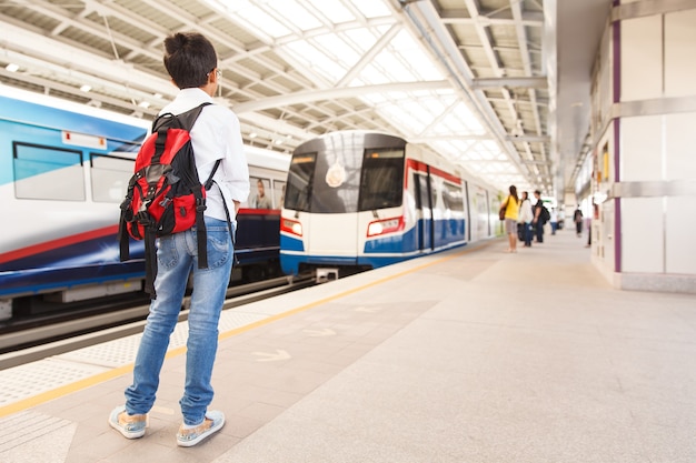 Jonge jongen wacht op sky train in Bangkok, Thailand