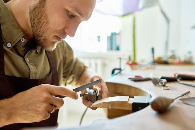 Foto jonge juwelier making ring closeup